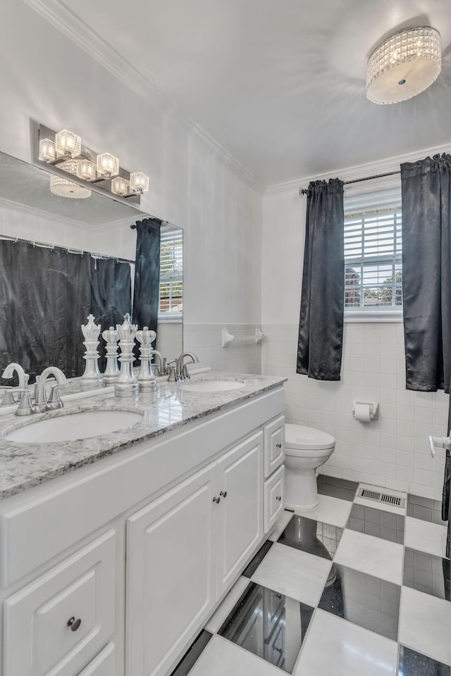 bathroom featuring toilet, ornamental molding, tile walls, and vanity