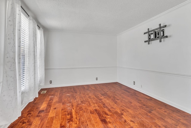 spare room featuring a textured ceiling, crown molding, and wood-type flooring