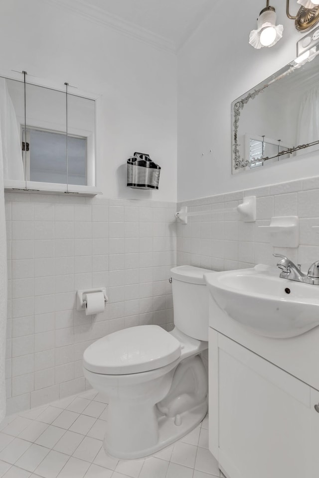 bathroom featuring toilet, tile walls, tile patterned floors, crown molding, and vanity