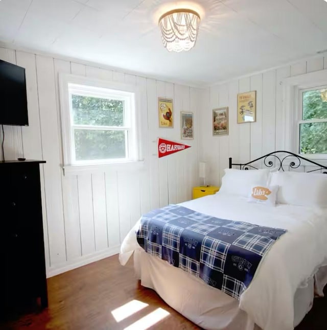 bedroom with dark hardwood / wood-style floors and multiple windows