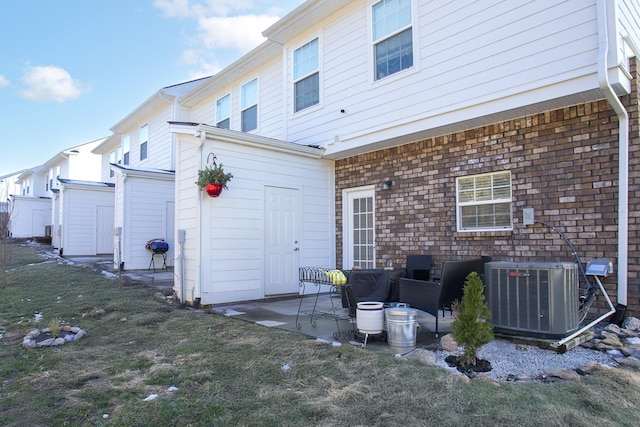 back of property with a patio area, central AC, and a yard