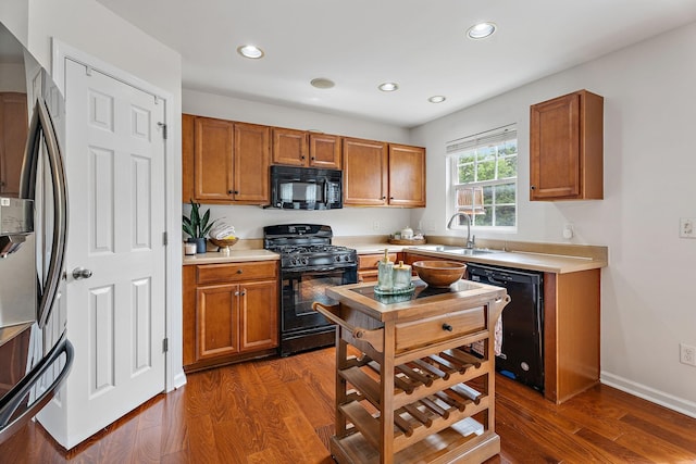 kitchen with sink, dark hardwood / wood-style floors, and black appliances