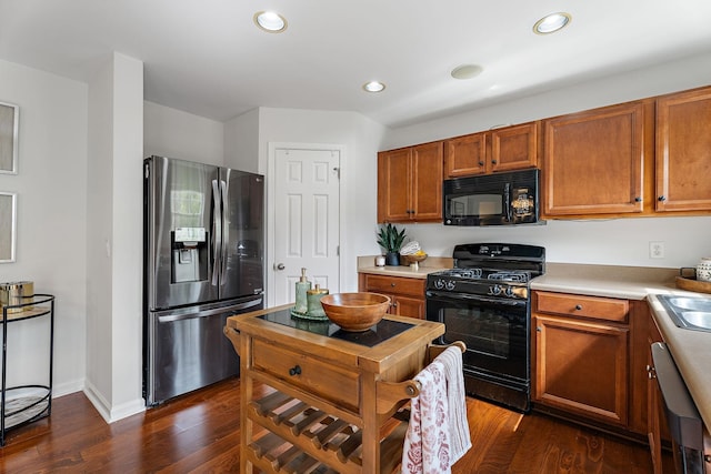 kitchen with dark hardwood / wood-style flooring, sink, and black appliances