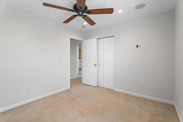 unfurnished bedroom featuring ceiling fan, light colored carpet, and a closet