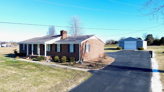 view of front of house featuring a garage, a front lawn, and an outdoor structure