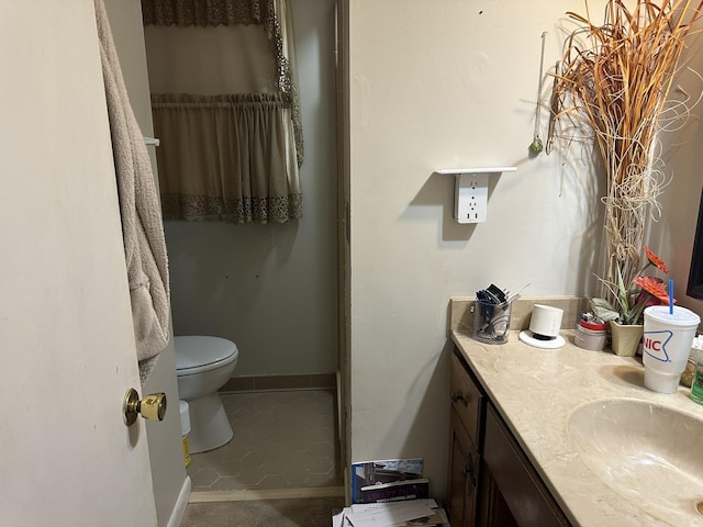 bathroom featuring toilet, vanity, tile patterned flooring, and walk in shower