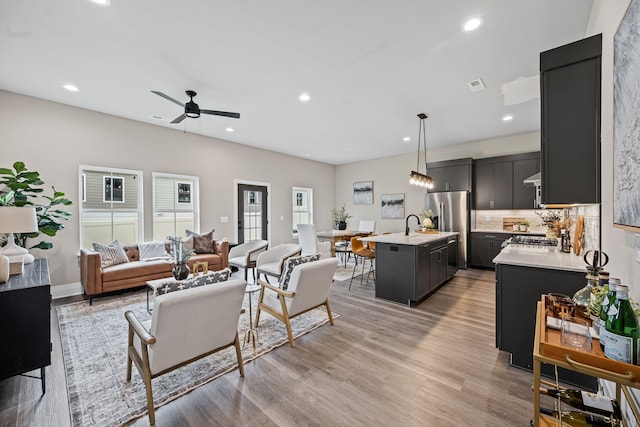 living room with ceiling fan and light hardwood / wood-style floors