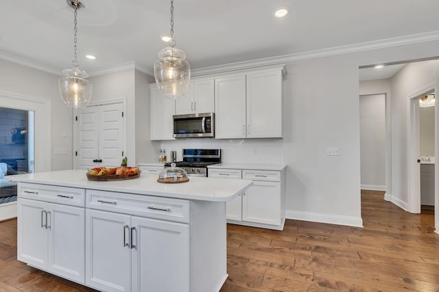 kitchen with white cabinetry, decorative light fixtures, a center island, and appliances with stainless steel finishes