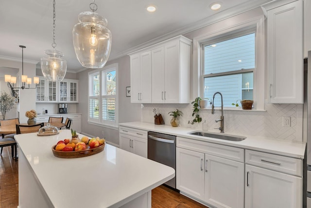 kitchen with sink, hanging light fixtures, stainless steel dishwasher, a kitchen island, and white cabinets