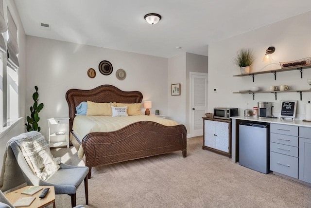 bedroom featuring light colored carpet and stainless steel fridge