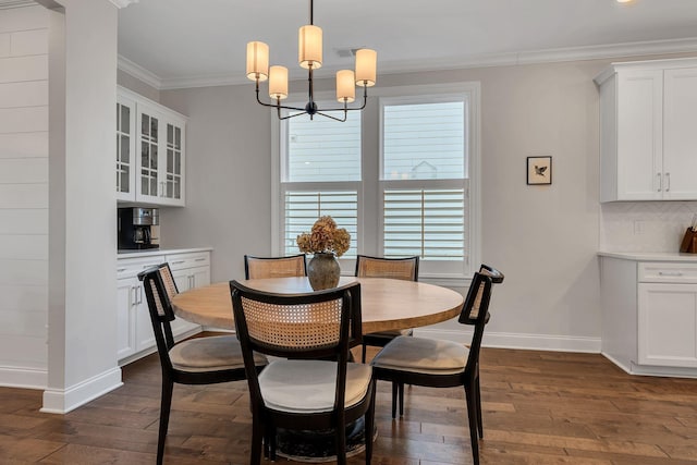 dining area featuring crown molding, dark wood-type flooring, and a chandelier