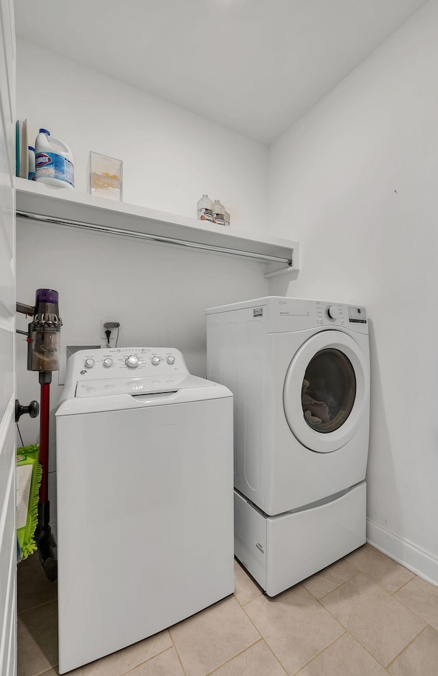 laundry room with light tile patterned flooring and washer and clothes dryer