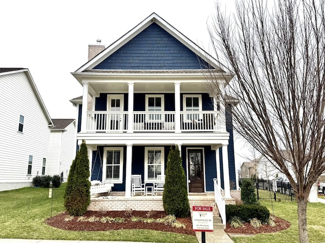 view of front of house with covered porch and a front lawn