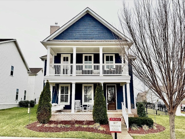 view of front of property featuring covered porch and a front yard