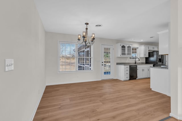 kitchen with a chandelier, white cabinets, light wood-type flooring, and black appliances