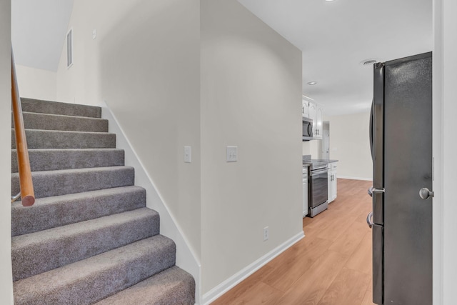 stairs featuring hardwood / wood-style floors