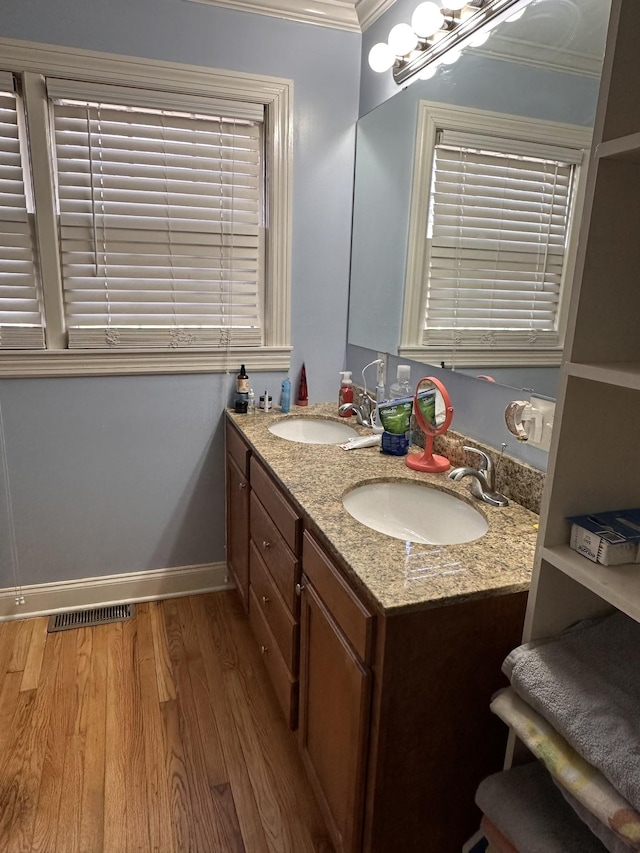 bathroom with hardwood / wood-style floors, vanity, and crown molding