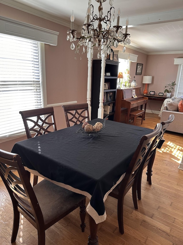 dining area with light hardwood / wood-style floors, a wealth of natural light, and ornamental molding