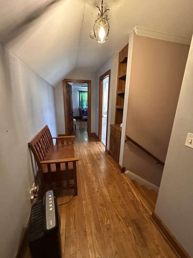 hall with lofted ceiling and hardwood / wood-style flooring