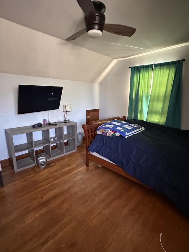 bedroom with ceiling fan, hardwood / wood-style floors, and vaulted ceiling