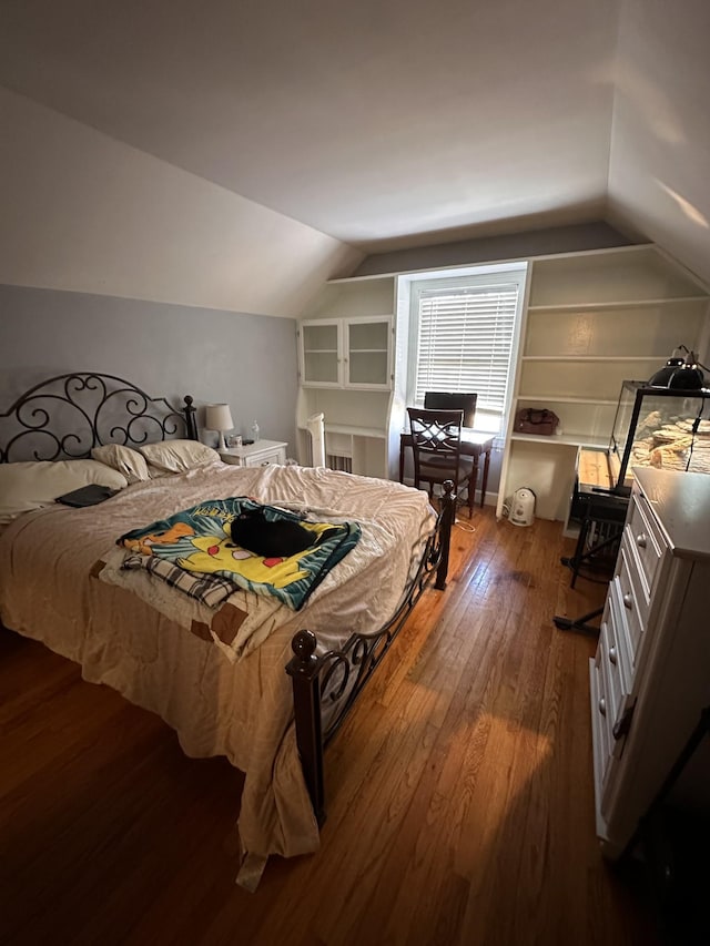 bedroom featuring lofted ceiling and hardwood / wood-style floors