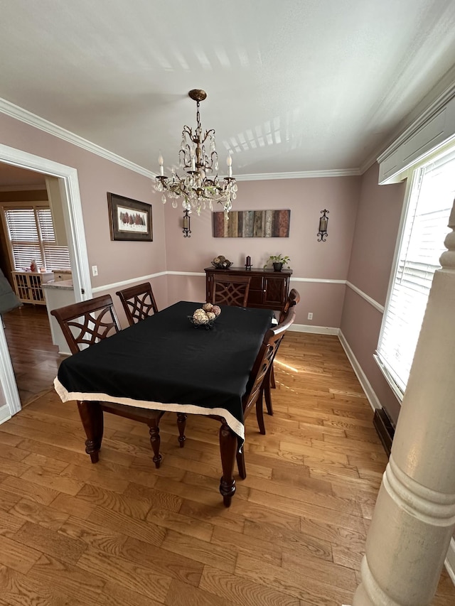 recreation room featuring decorative columns, crown molding, a chandelier, and light hardwood / wood-style floors