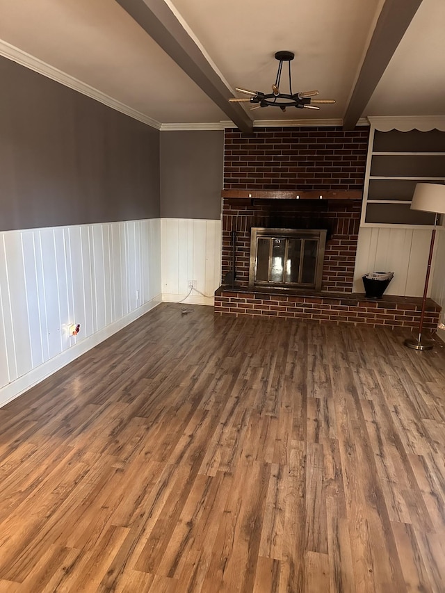 unfurnished living room featuring a fireplace, crown molding, beam ceiling, and hardwood / wood-style floors