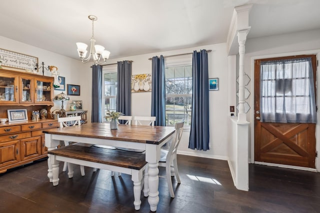 dining space with plenty of natural light, dark hardwood / wood-style floors, and a notable chandelier