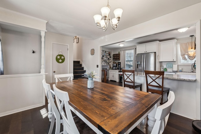 dining room with dark wood-type flooring and an inviting chandelier