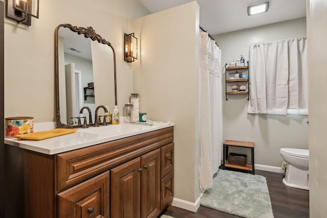 bathroom featuring vanity, wood-type flooring, and toilet