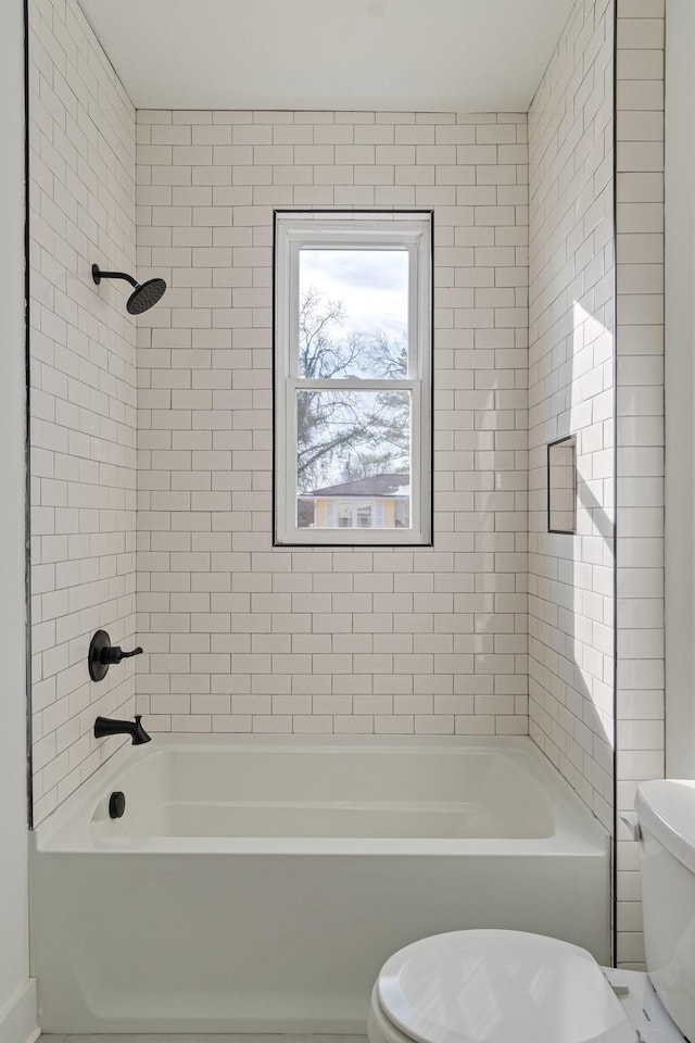 bathroom featuring toilet and tiled shower / bath combo