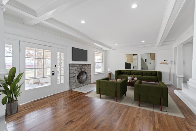 living room featuring beam ceiling, a healthy amount of sunlight, coffered ceiling, and hardwood / wood-style flooring