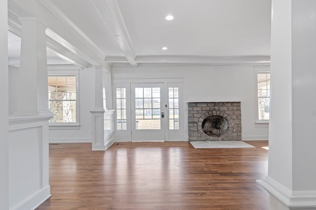 unfurnished living room with hardwood / wood-style flooring, beamed ceiling, and a healthy amount of sunlight