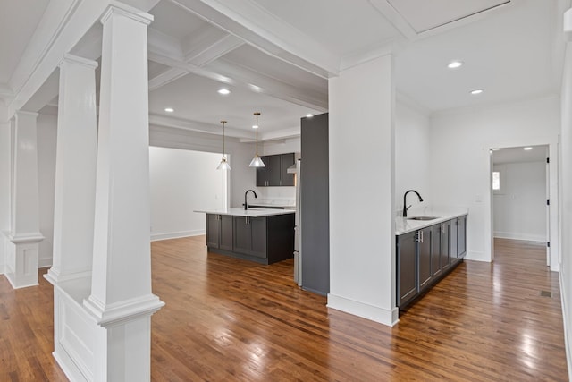 kitchen featuring dark wood-type flooring, decorative light fixtures, beam ceiling, and sink