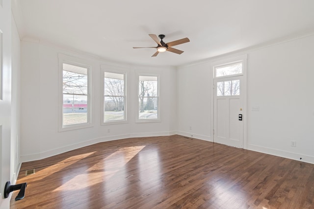 empty room with ceiling fan, plenty of natural light, and dark hardwood / wood-style flooring