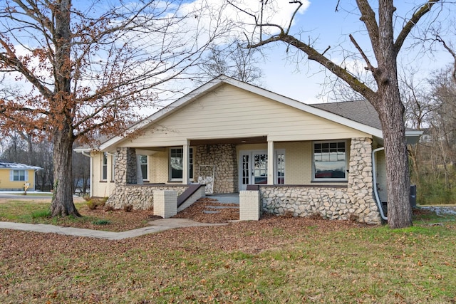 bungalow-style house featuring covered porch and a front lawn