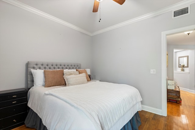 bedroom featuring ceiling fan, wood-type flooring, and crown molding