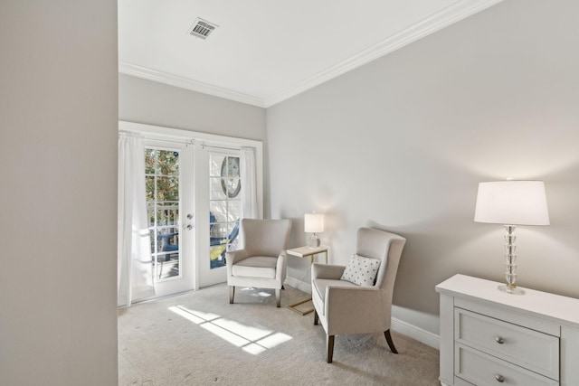 sitting room featuring french doors, crown molding, and light carpet