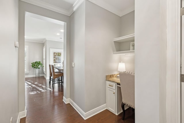 bar with white cabinetry, light stone counters, built in desk, ornamental molding, and dark hardwood / wood-style floors