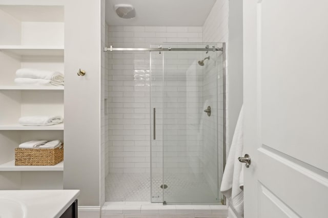 bathroom with a shower with door and vanity