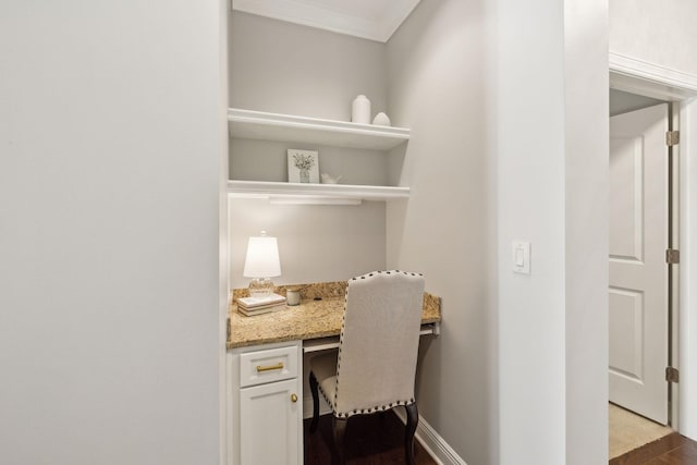 office area with crown molding, built in desk, and wood-type flooring