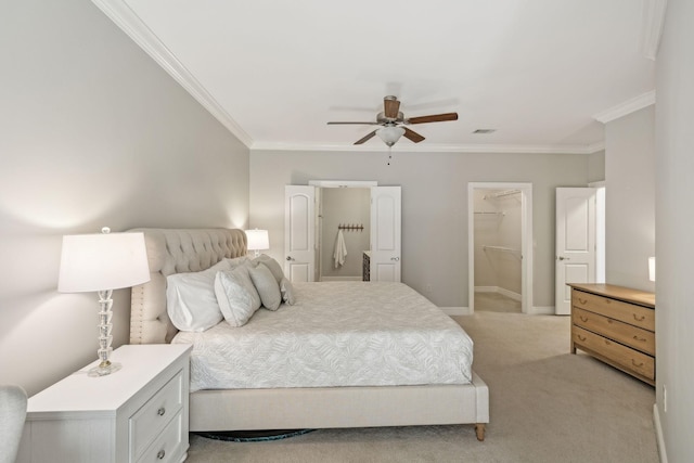 carpeted bedroom featuring crown molding, a spacious closet, ceiling fan, and a closet