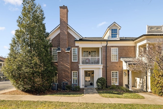 view of front of property with central AC unit and a balcony