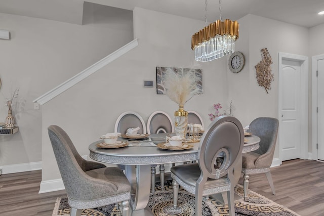 dining space featuring wood-type flooring and a chandelier