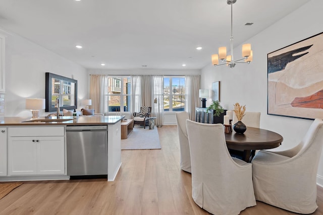 dining area featuring a chandelier, light hardwood / wood-style floors, and sink