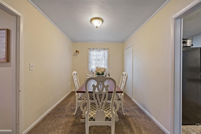 carpeted dining room featuring a textured ceiling and crown molding