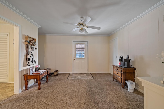 carpeted foyer entrance with ceiling fan and crown molding