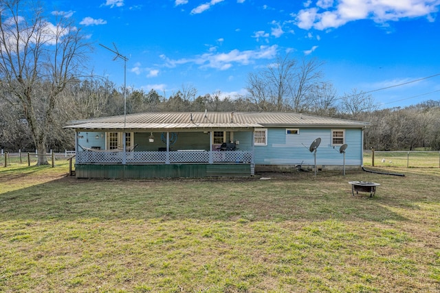 view of front facade with a deck, a fire pit, and a front lawn