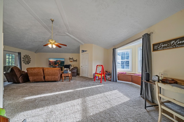 rec room featuring lofted ceiling, ceiling fan, and a textured ceiling