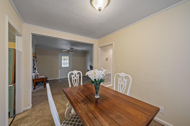 dining area with ceiling fan, carpet, and ornamental molding